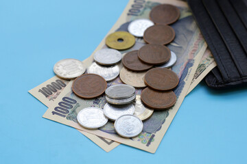 Japan money, Yen banknotes with coins on blue background.