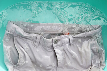 Trousers soaked in powder detergent water dissolution, washing cloth. Laundry concept
