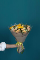 hand holding a beautiful bouquet of flowers on a plain background