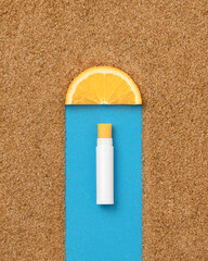 Lip orange balm among brown sugar. Natural hygienic lipstick with orange. Lip care cosmetics. Creative cosmetics advertising concept. Copy space. Zero waste concept. Top view. High quality photo