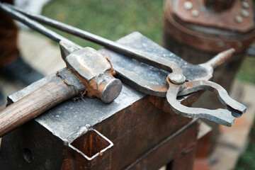 closeup of a blacksmith anvil with a hammer and pliers