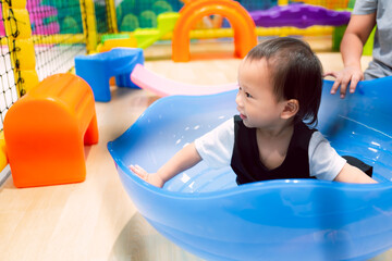 Child having fun in the balance toy and playground room with parent. Happy funny. Sweet smile boy...