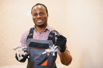 African american plumber holding faucet