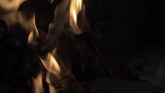 An open book burning in a fire of dry vets at night in an ancient building in oriental style