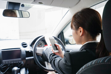 営業車で電話をするキャリアウーマン