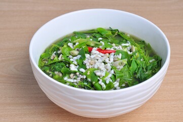 Sweet vegetable curry with red ant eggs Local food on white bowl on brown wooden table