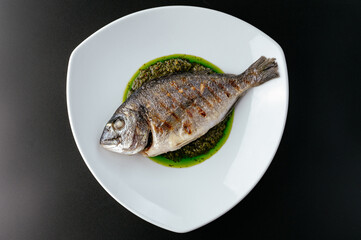 grilled dorado with sauce on a plate