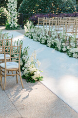 white florals with gold chairs at wedding ceremony