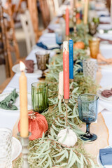 Table setting with tall tapered candles, vintage drink-wear and plates