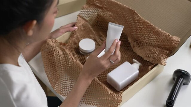Asian woman online seller packing package post shipping box preparing delivery parcel on table. Ecommerce dropshipping shipment service concept.