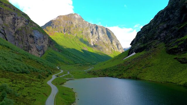 Norweigan Fjords Stavbergvatnet Urke, a small pond surrounded by green mountains in Norway
