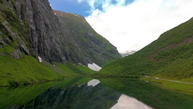 Norweigan Fjords Stavbergvatnet Urke, a picturesque lake in a valley, surrounded by majestic mountains. The calm water reflects the stunning natural beauty, creating a breathtaking scene
