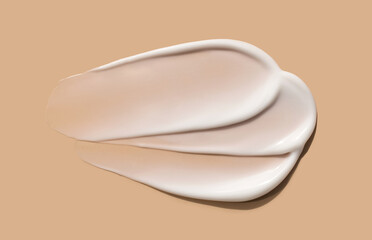 cosmetic smears of creamy texture on a beige background