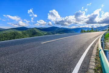 Asphalt highway road and green mountain nature landscape under blue sky