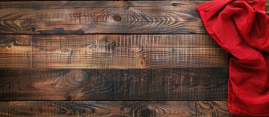 Red tablecloth on wooden tabletop, seen from above with space for text.