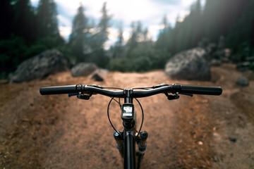 Embracing Freedom on Forest Trails with Mountain bike with air suspension fork. Bike POV handlebar.