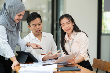 Group of Asian business people planning a project, discussing work documents.