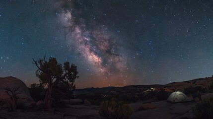 A cozy campsite under a star-studded sky in the wilderness, with the Milky Way clearly visible