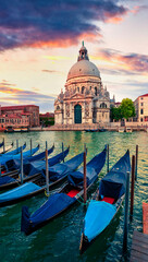 Dramatic spring sunset with Basilica di Santa Maria della Salute church in Venice, Italy, Europe. Splendid evening seascape of Adriatic Sea. Traveling concept background.