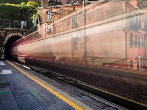 Long exposure showing blur of train going through station in Italy.