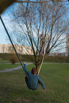 Young man sitting on a slackline.