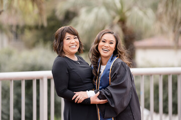 Mom and daughter laughing together while holding each other in g