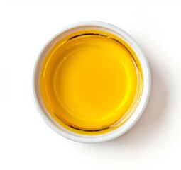 Top view of yellow liquid in a petri dish or glass with bubbles on a white background.