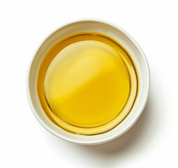 Top view of yellow liquid in a petri dish or glass with bubbles on a white background.