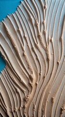 Fototapeta premium The image shows a textured surface with a light beige or off-white color. The surface appears to have been coated with a thick layer of plaster or stucco , giving it an uneven, rough texture.
