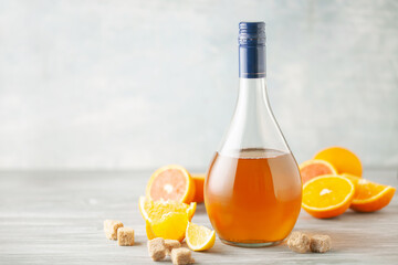Homemade orange infused vodka, tincture or liqueur of citrus on light background. Fruit alcoholic drinks concept.