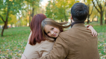 Obraz premium Caucasian happy family weekend holiday nature outdoors in city autumn park bonding love Back view loving parents mother father catch hug cuddling little child kid girl daughter running hugging smiling