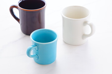 コーヒーを飲むために、お気に入りのおしゃれな3つのマグカップから、今日のひとつを選ぶ
