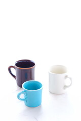 コーヒーを飲むために、お気に入りのおしゃれな3つのマグカップから、今日のひとつを選ぶ
