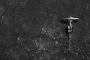 One corkscrew on grey textured table, top view. Space for text