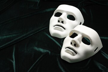 Theater arts. White mask on green fabric, space for text