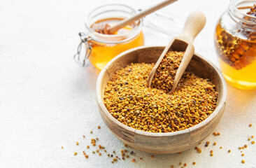 Raw organic bee pollen and honey in jars. .
