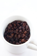 コーヒーカップと、深煎りしたコーヒー豆
