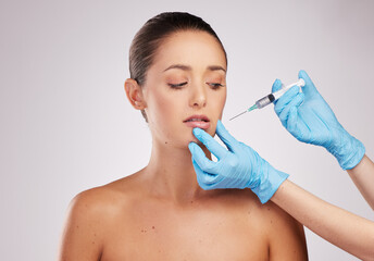 Woman, beauty and needle in hand for plastic surgery with facelift and medical procedure in studio. Female client, cosmetic transformation and surgeon syringe for liquid collagen by white background