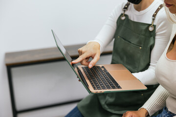 Professional microblading artist providing customer service and consultation via laptop