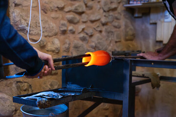 Artisans making a blown glass vase in a workshop