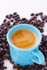 エスプレッソに牛乳をたっぷり入れたコーヒー、カフェ・ラッテと、深煎りしたコーヒー豆
