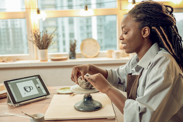 Obraz premium Young female sculptor working on new ceramic products