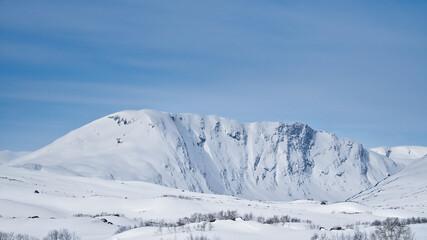 Obraz premium Norwegian high mountains in the snow. Mountains covered with snow. Scandinavia