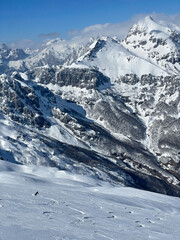 Beautiful snowy mountain scenic with a freeride skier riding fresh powder snow