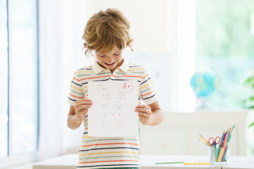 Child holding school test with excellent A grade.