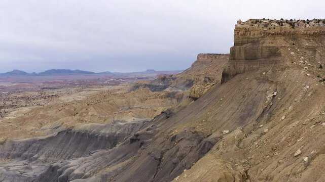 Aerial view of a towering butte in Moab, Utah, desert rugged terrain and canyon landscape.