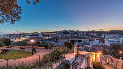 Obraz premium Panorama showing Jardim do Torel day to night timelapse with views to the city center of Lisbon after sunset. Portugal