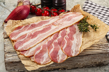 Sliced pork bacon over board
