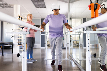 Biracial man using virtual reality headset for rehabilitation exercises