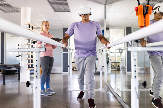 Biracial man using virtual reality headset for rehabilitation exercises